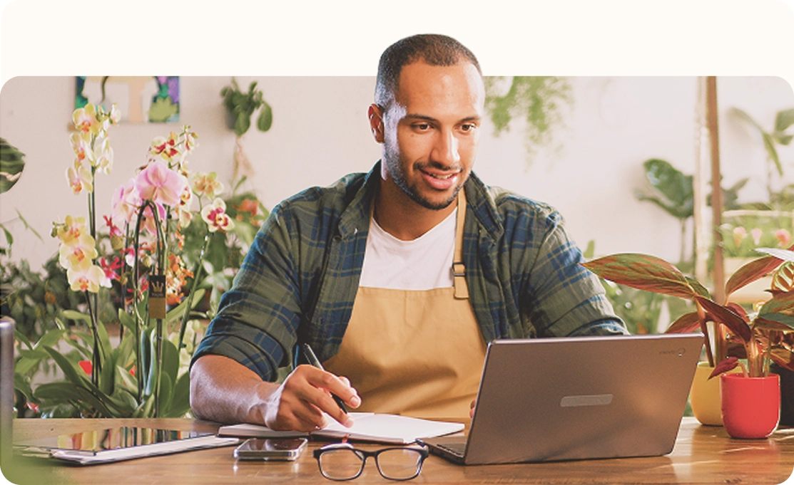 Man working on laptop in plant shop